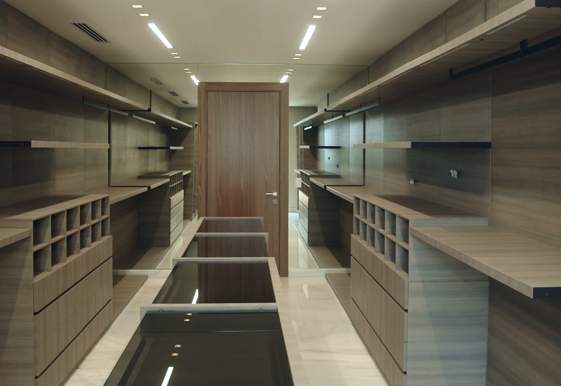 Vestidor a medida con módulos en chapa de madera y frentes en cristal lacado