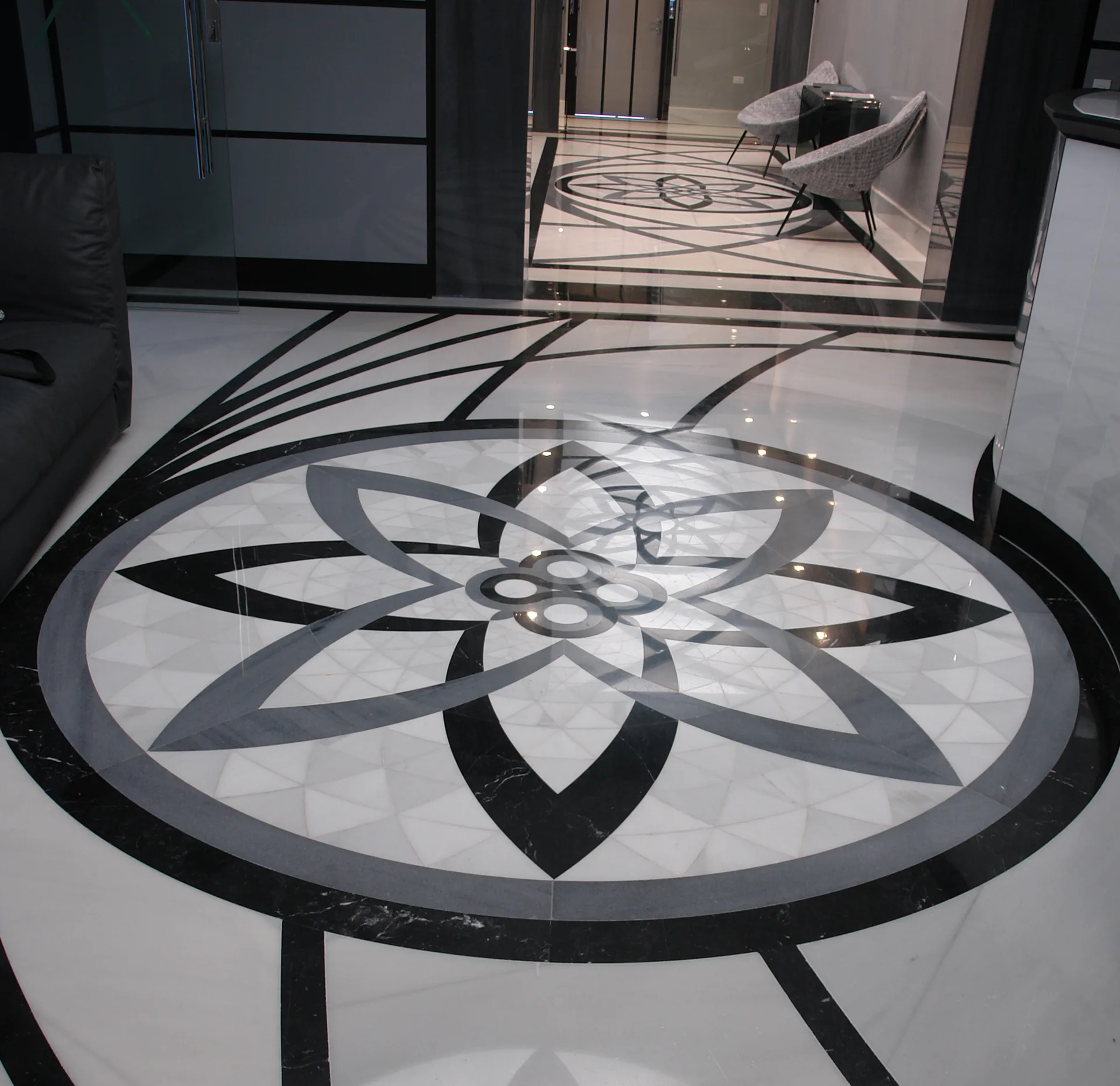 Roseta de mármol blanco y Negro Marquina realizada con técnica water jet en el hall de acceso