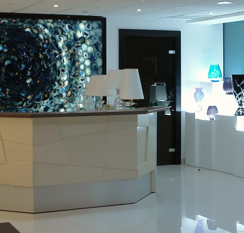 Recepción con mostrador facetado y panel de ágata azul retroiluminado