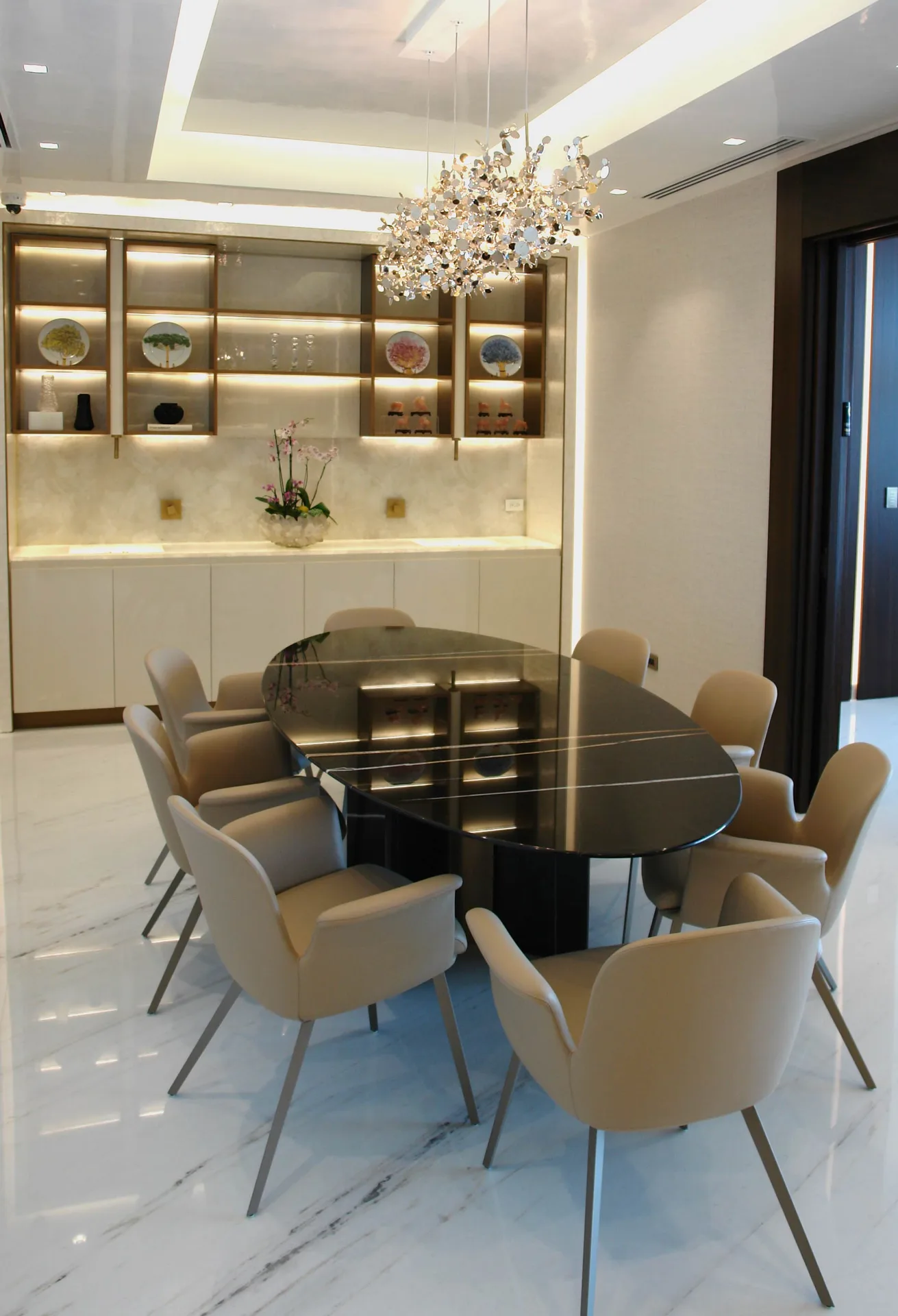 Comedor con mesa ovalada en mármol negro y lámpara escultórica